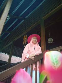 Low angle view of young woman standing against building