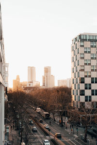 Road amidst buildings against clear sky