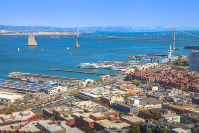 High angle view of cityscape by sea against clear sky