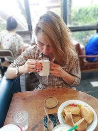 Woman sitting on table at restaurant