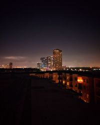 Illuminated buildings against sky at night