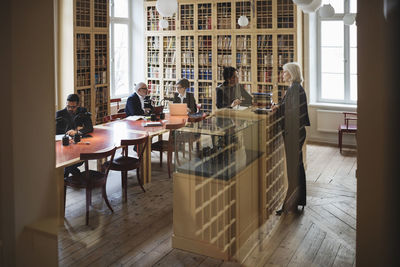 Lawyers working in library seen through glass in library