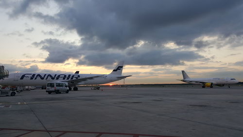 Airplane on airport runway against sky