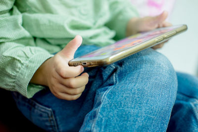 Midsection of man holding paper while sitting outdoors