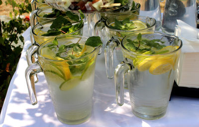 Glasses with a cold drink and lemon slices on a garden table ready for an event 