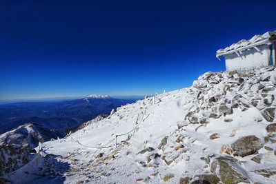 Scenic view of snowcapped mountains against clear blue sky