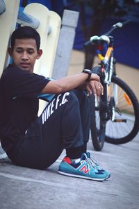 Boy with bicycle on road in city