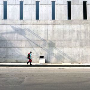 Rear view of man walking on footpath