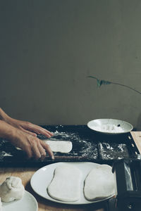 Cropped hand of man preparing food on table