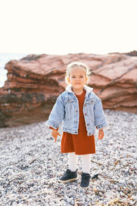 Portrait of girl standing on rock