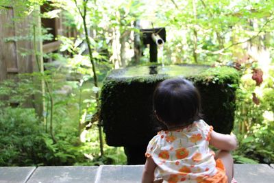 Rear view of baby with fountain in background