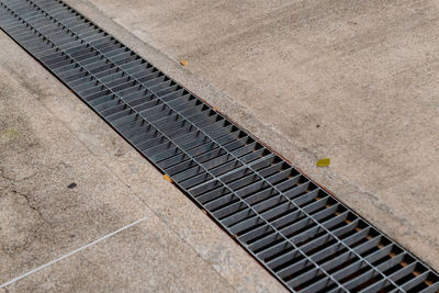 High angle view of tiled floor with steel grating drain