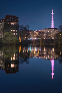 Reflection of buildings in lake at night