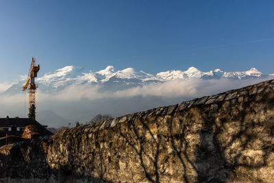 Low angle view of building and mountains against sky