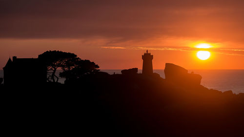 Silhouette buildings against sky during sunset