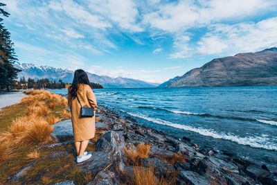 Rear view of man looking at sea against sky