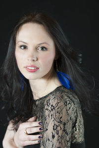 Close-up of young woman against black background