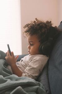 Boy holding mobile phone at home