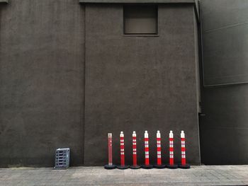 Reflective bollards on footpath against gray building