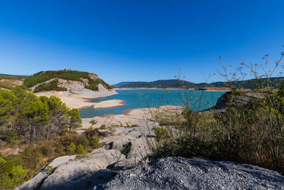 Scenic view of lake against clear blue sky