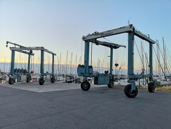 Bicycles by pier at harbor against clear sky