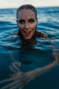 Young woman with golden skin in water