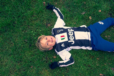 High angle view of boy lying on field