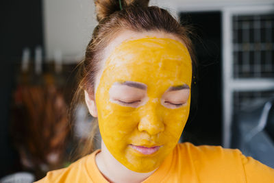 Close-up of young woman with facial mask