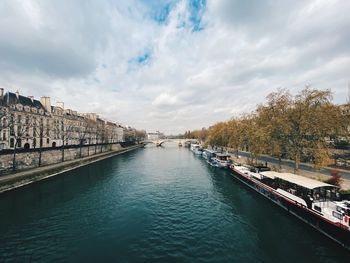 Bridge over canal in city against sky