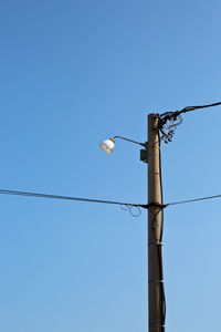 Low angle view of street light against clear blue sky