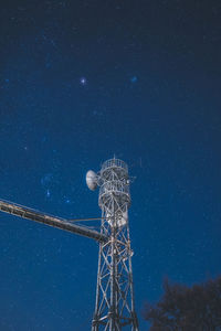 Low angle view of electricity pylon against sky at night