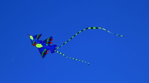 Low angle view of kite against blue sky