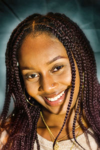 Close-up portrait of smiling young woman wearing hat at home