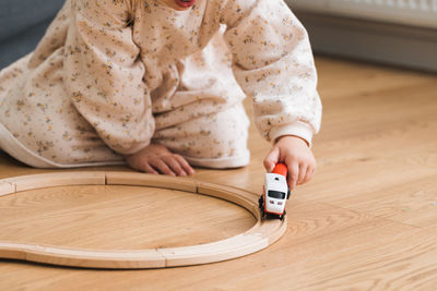 Low section of girl playing with toy train