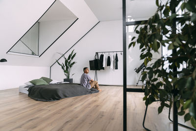 Man sitting on bedding at home