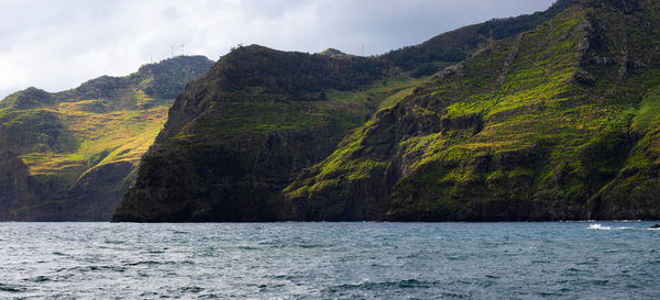 Scenic view of sea and mountains against sky