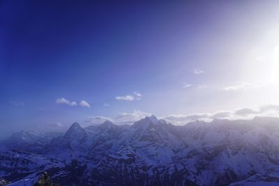 Scenic view of snowcapped mountains against blue sky