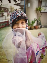 Portrait of girl wearing hijab while standing at yard
