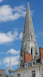 Low angle view of bell tower against cloudy sky