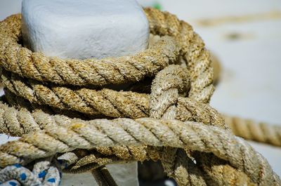 Close-up of rope tied to bollard at harbor