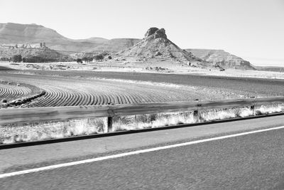 Road leading towards mountains against clear sky