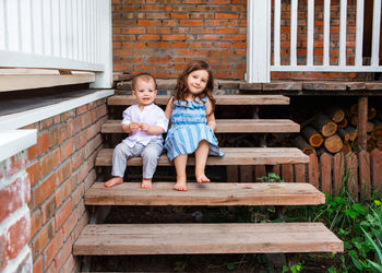 Portrait of a smiling girl sitting on wood