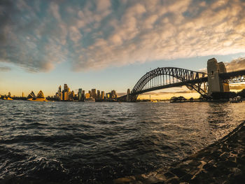 View of bridge and buildings against sky during sunset