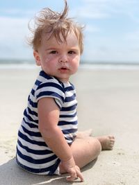 Portrait of cute boy sitting on beach