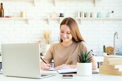 Young woman using phone on table