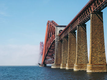 Low angle view of bridge over sea against sky