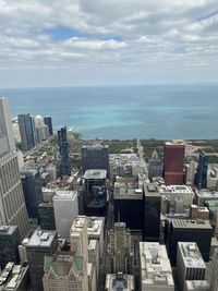 High angle view of buildings by sea against sky