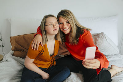 Sisters on bed taking selfie