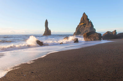 Rocks on beach against sky