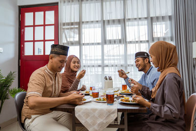 Happy couples having food at home